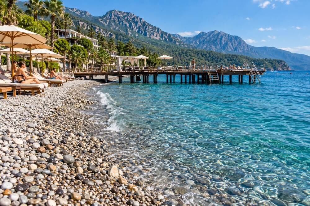 Żwirowa plaża hotelowa w Turcji z pomostem do morza