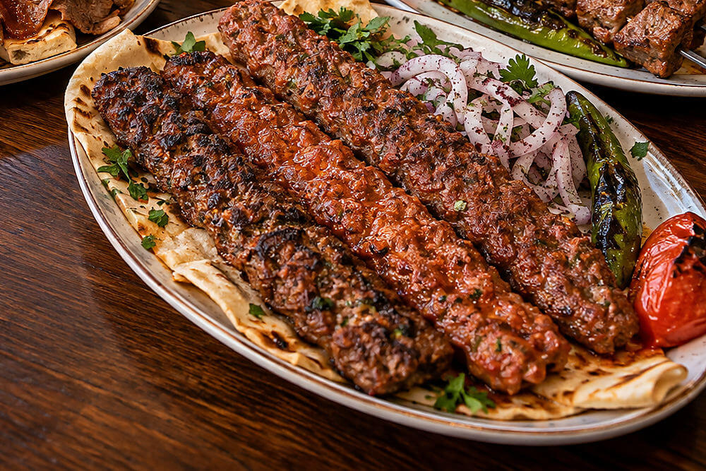Adana kebabı na lawaszu z cebulą i grillowaną papryką
